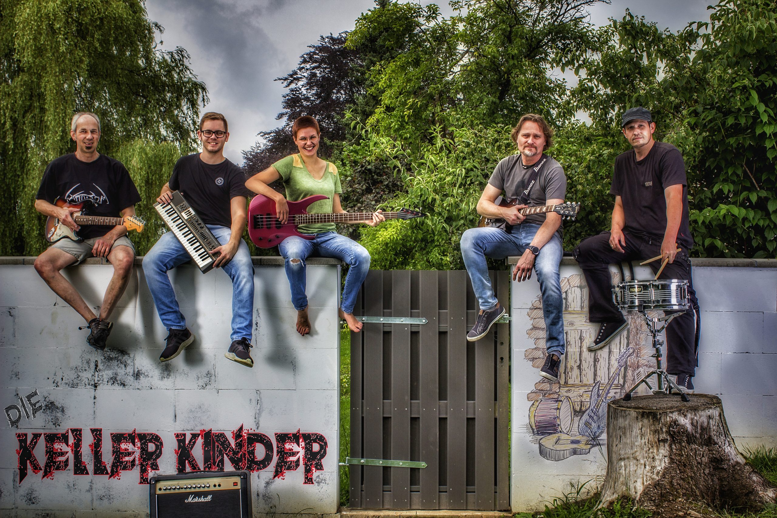 Die Kellerkinder Stefan (Gitarre), Ralf (Keys), Betti (Bass), Michael (Gitarre) und Michael (Drums) sitzen jeweils mit ihrem Instrument auf einer Mauer. Auf der Mauer ist das Bandlogo "Die Kellerkinder" in schwarz-roter Schrift.